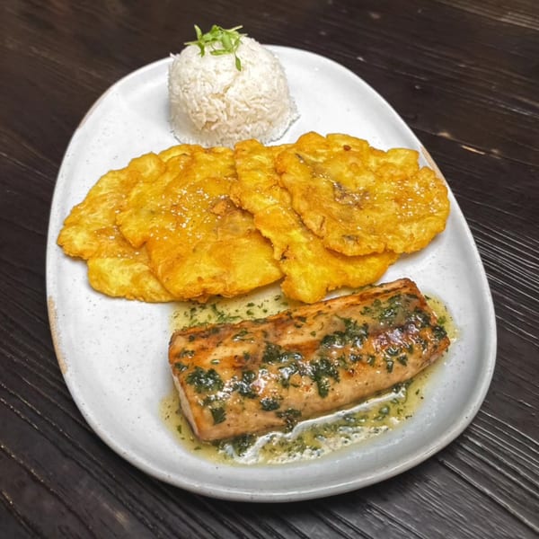 Bocas Grill's salmon with herb sauce, white rice, and fried plantains on a white plate.