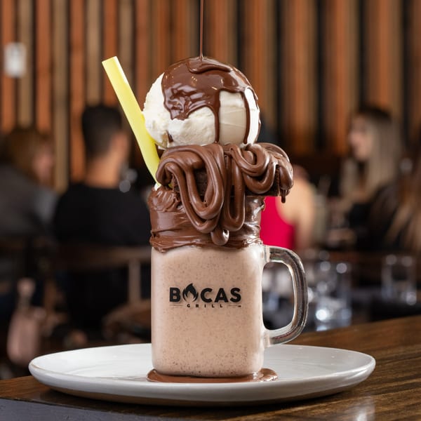 Bocas Grill milkshake in a mug, topped with ice cream, chocolate syrup, and brownies.