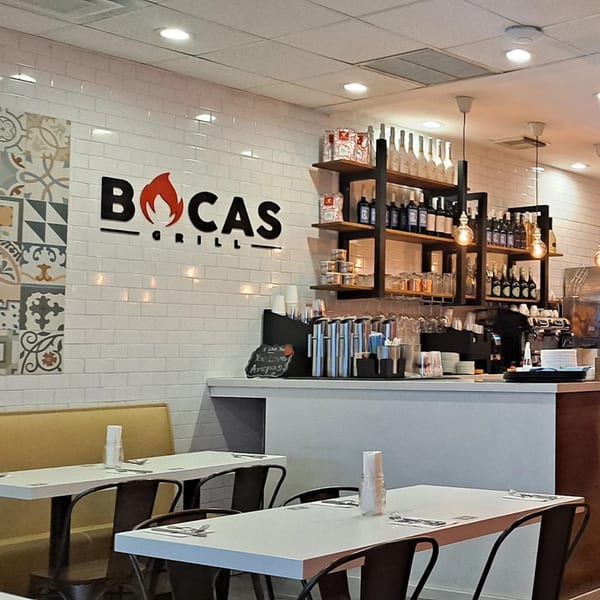 Interior of Bocas Grill restaurant with white subway tile, patterned accents, and a bar area.