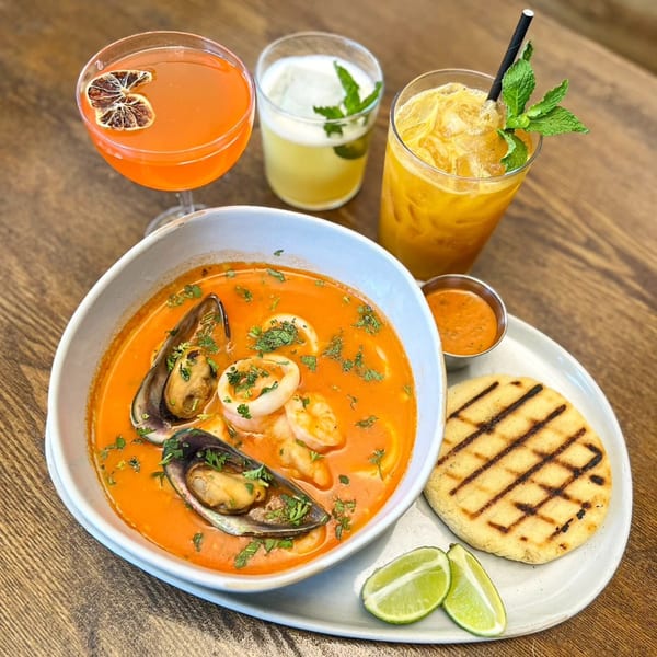 Bocas Grill's seafood soup with mussels, shrimp, and squid, served with an arepa and three cocktails.
