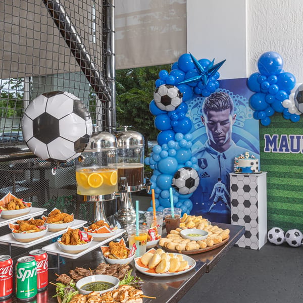A soccer-themed party table with Latin-American food, drinks, and a Cristiano Ronaldo backdrop.